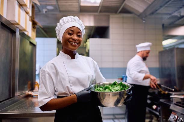 Une cuisinière préparant un plat dans sa cuisine professionnelle